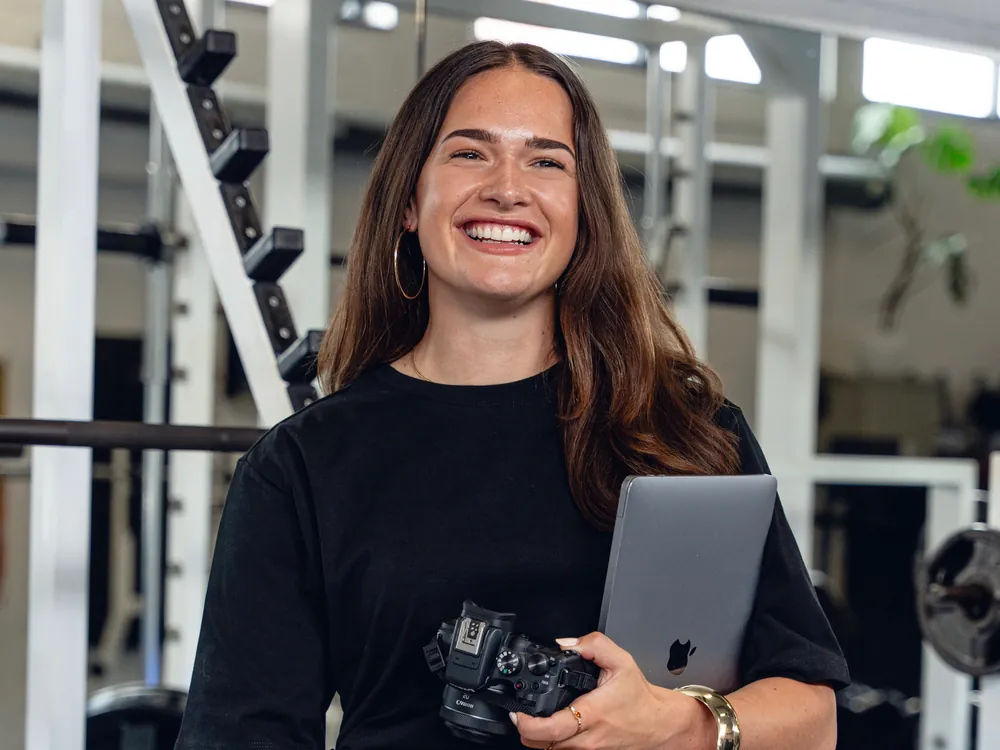 Karin Polstra met camera en laptop in de sportschool